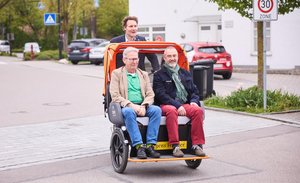 Ludwig Hartmann beim Rikschafahren. Mit im Bild zweiter Bürgermeister Roland Dörfler und Werner Weyers, stv. Gesamtleitung Regens Wagner.